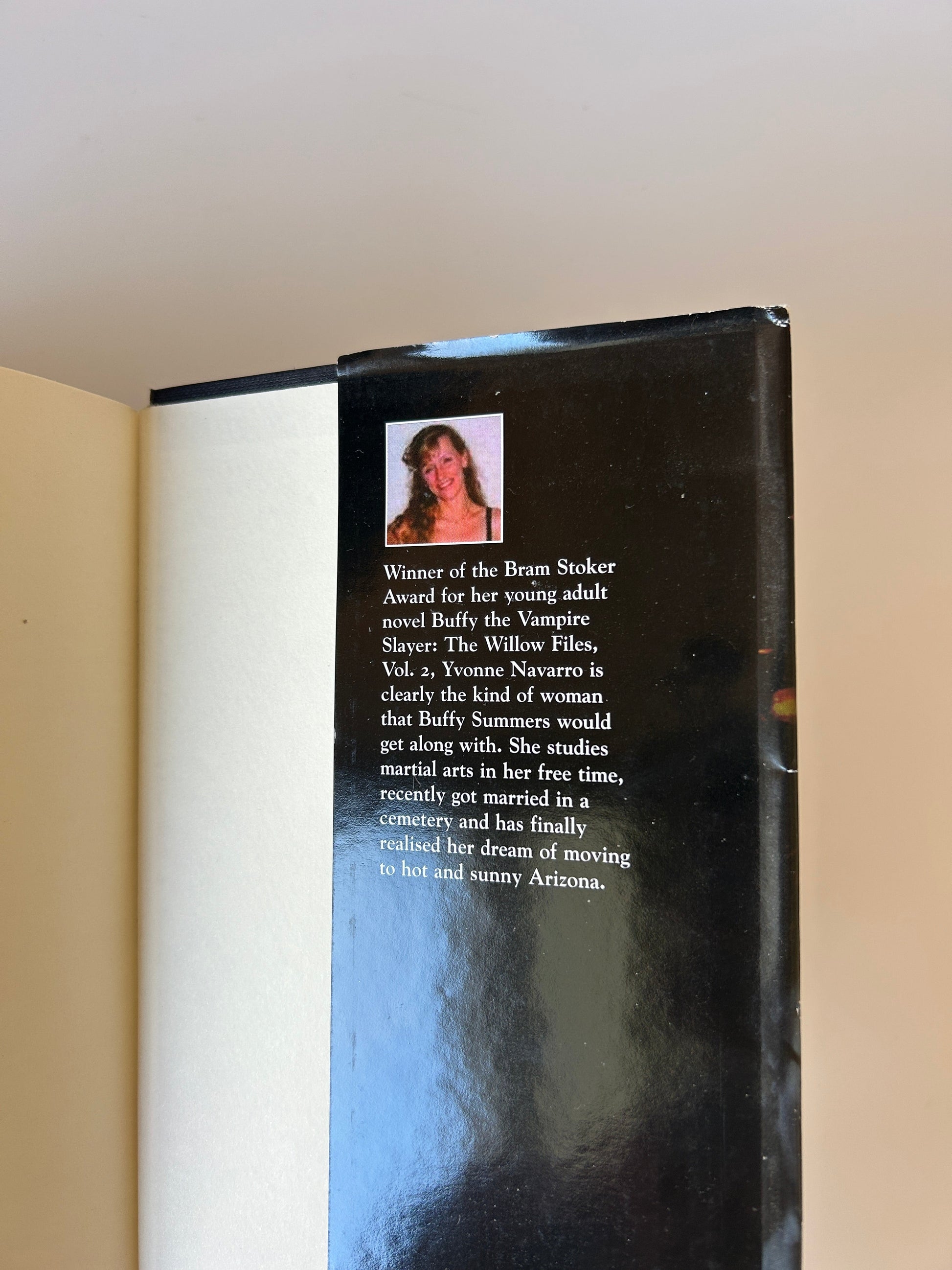 Book with a black back cover displaying text and a small photo of a woman.
