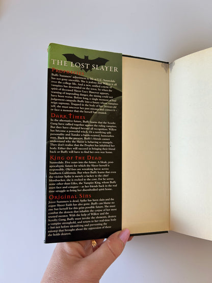 Open book with a hand holding it, displaying text on the pages.
